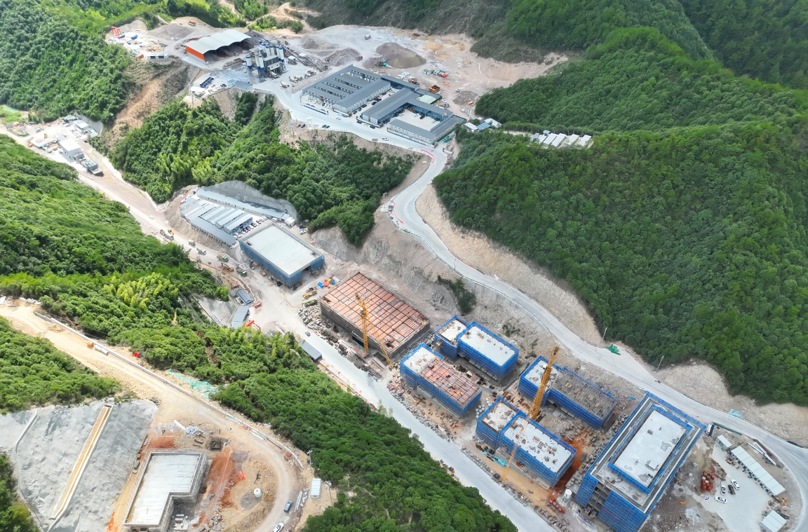 Aerial view of a hydropower construction area in a green valley
