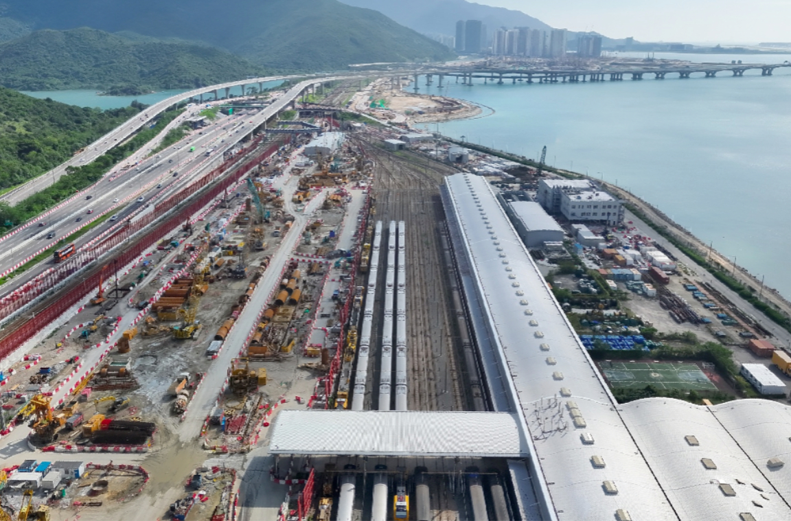 Aerial view of road and rail construction alongside a bridge and shoreline
