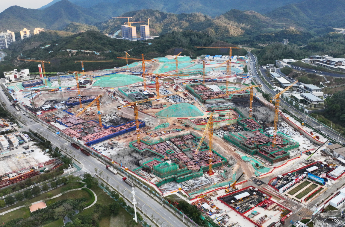 Aerial view of a large university construction site with multiple cranes